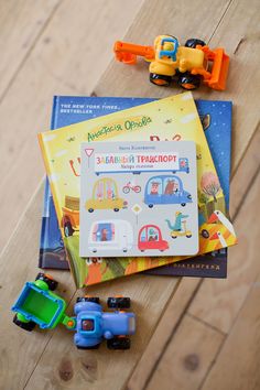 children's books and toy vehicles on a wooden table