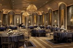 an elegant ballroom with chandeliers, tables and chairs