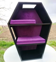 a purple and black shelf sitting on top of a white table