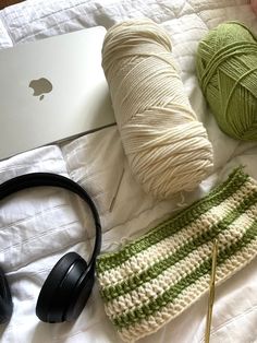 yarn, headphones and laptop on a bed