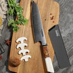 a large knife sitting on top of a cutting board next to some cut up vegetables