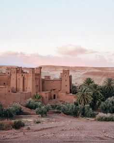 an adobe - style building in the desert with palm trees