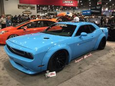 several different colored cars on display at an auto show