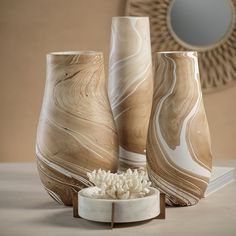 three vases sitting on top of a table next to a bowl filled with rice