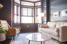 a living room with two couches and a coffee table in front of the window