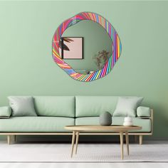 a living room with a green wall and a circular mirror on the wall above it