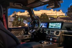 the interior of a vehicle with a view of a castle in the background at night