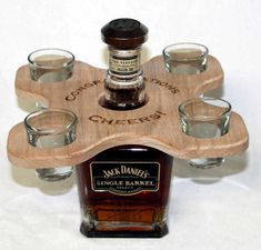 a bottle of jack daniels single barrel whiskey with shot glasses on the bottom and wooden coaster