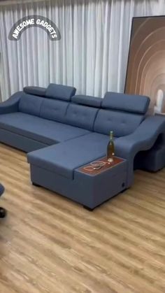 a blue sectional sofa sitting on top of a hard wood floor next to a chair