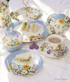 a table topped with plates and cups filled with food