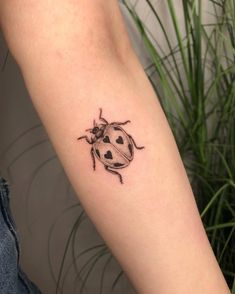 a ladybug tattoo on the left arm