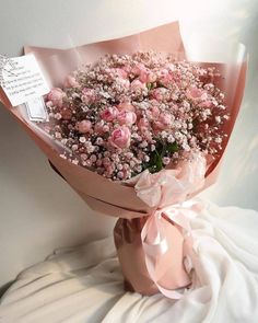 a bouquet of pink flowers is wrapped in paper