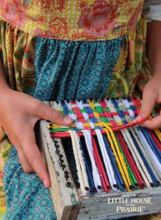 a woman is holding a box full of bracelets in her hands, with the words little house prairie written on it