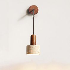 a wooden light fixture hanging from the ceiling in a room with white walls and flooring