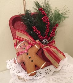 a gingerbread man ornament in a red box on a lace doily