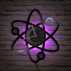 a clock that is on the side of a brick wall with an atomic symbol in front of it