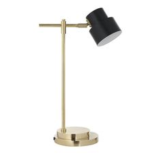 a black and gold desk lamp on a white background, with the light turned off