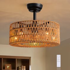 a wicker light fixture hanging from the ceiling in a room with built - in bookshelves