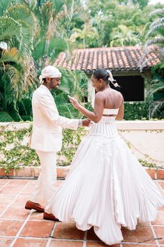 a man and woman in wedding attire standing next to each other on a tile floor