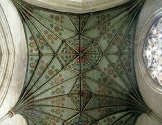 an ornate ceiling in the middle of a building with stained glass and flowers on it