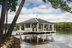 a gazebo sitting on top of a lake surrounded by trees