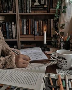 a person sitting at a table with books and a coffee cup in front of them