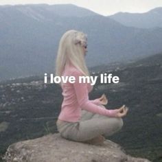 a woman sitting on top of a rock with the words i love my life in front of her