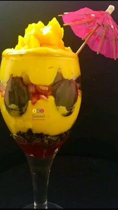 a yellow drink in a glass with sunglasses and an umbrella sticking out of the top