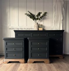 two black dressers sitting next to each other on top of a wooden floor