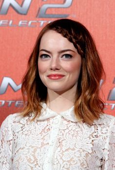 a woman with red hair wearing a white dress and black heels at the spider - man paris photocalp