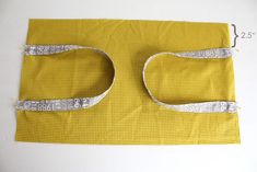 a piece of yellow fabric with silver sequins on it and measuring tape in the middle