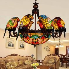 a chandelier hanging from the ceiling in a living room with chairs and couches