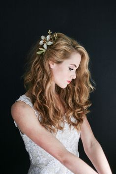 a woman wearing a white dress and holding a knife in her hand with flowers on it