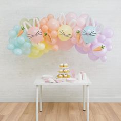 a white table topped with lots of balloons