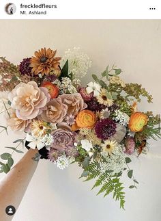 a vase filled with lots of flowers on top of a table