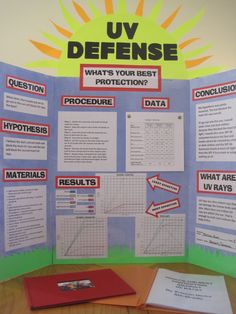 a poster with information about uy defense on the front and behind it is a red folder