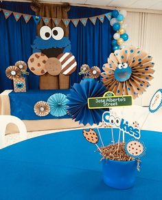 a cookie themed party with blue table cloths, paper fans and cupcake toppers