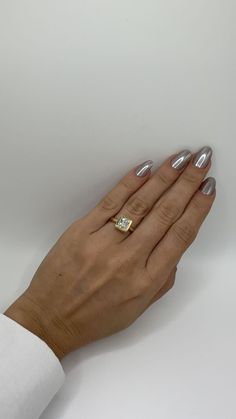 a woman's hand holding a diamond ring on top of her left hand, against a white background