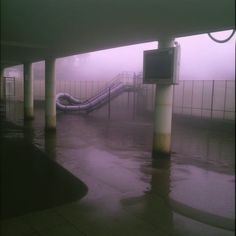 a water slide in the middle of a parking lot with no one around it on a foggy day