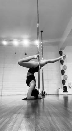 a woman is doing an acrobatic move on the floor in a dance studio