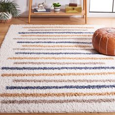 a white rug with blue, yellow and brown stripes on it in a living room