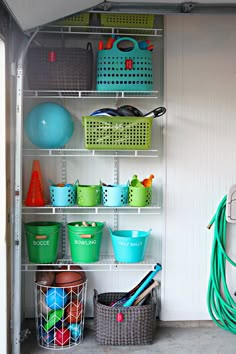 an organized garage storage area with baskets, buckets and other items on shelving