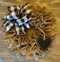 a burlocked wreath with a heart on it sitting on top of a wooden table