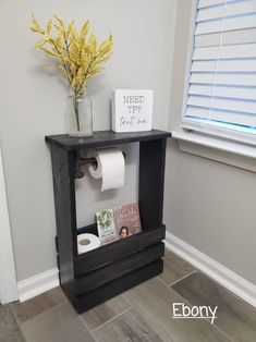 a toilet paper dispenser in a bathroom next to a window with yellow flowers