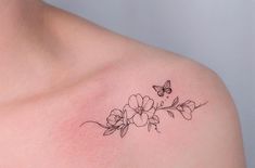 a woman's shoulder with flowers and a butterfly tattoo on the left side of her chest