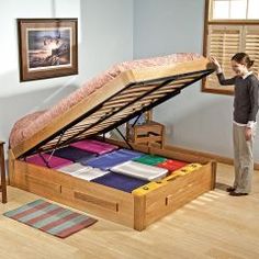 a woman standing next to an open bed frame