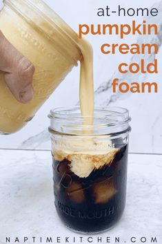 a person pouring ice cream into a mason jar with text overlay that reads at - home pumpkin cream cold foam