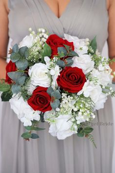 a bride holding a bouquet of red and white flowers