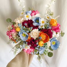 a hand holding a bouquet of colorful flowers