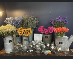 a table topped with lots of vases filled with different types of flowers and plants